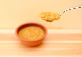 Image showing Spoonful of vegetable soup above the bowl