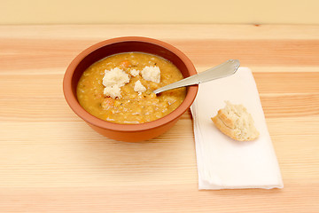 Image showing Bowl of soup served with pieces of bread roll