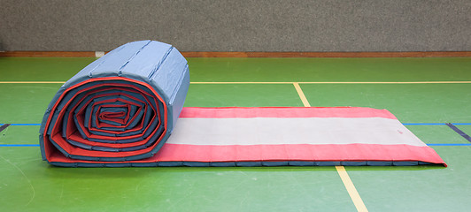 Image showing Very old long mat on a green court