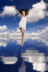 Image showing Girl jumping over the water
