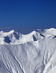 Image showing Off-piste slope with traces of skis and snowboards in sun day