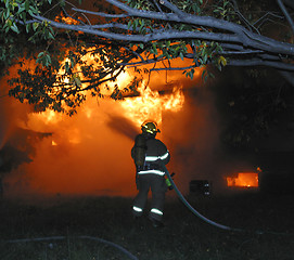 Image showing firefighter battles a house fire