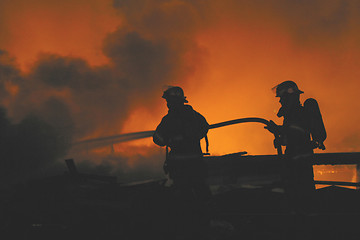 Image showing firefighters in silhouette