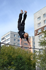 Image showing The man goes in for sports on a horizontal bar in a house yard