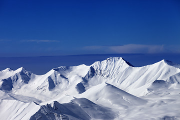 Image showing Snowy mountains at sunny day and multicolor blue sky