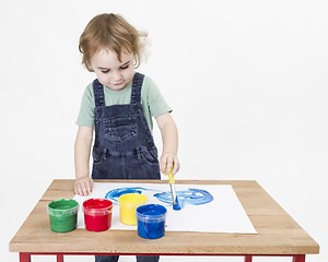 Image showing cute girl painting on small desk