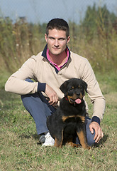 Image showing man and puppy rottweiler