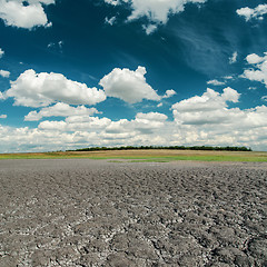 Image showing dark sky with clouds over cracked desert