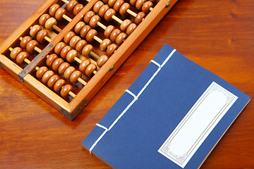 Image showing Chinese book , abacus and writing brush on the table