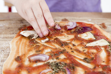 Image showing small hands preparing pizza