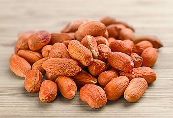 Image showing heap of raw peanuts on the wooden background