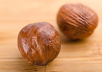 Image showing A pile of shell-less hazelnuts, isolated on textural wood backgr