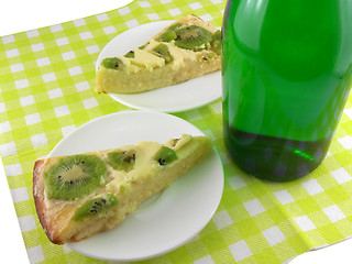 Image showing kiwi tasty cake close up at plate and champagne bottle