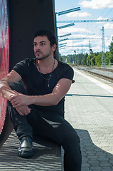 Image showing Handsome man sitting on platform