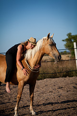 Image showing young woman training horse outside in summer