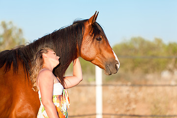 Image showing young woman training horse outside in summer