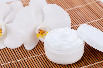 Image showing cosmetic face cream on wooden background 