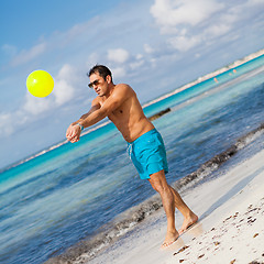 Image showing happy young adult man playing beach ball in summer 