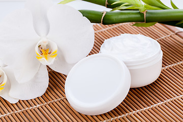 Image showing cosmetic face cream on wooden background 