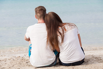 Image showing romantic young couple sitting on the beach in summer