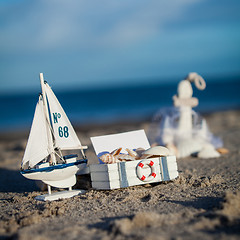 Image showing sailing boat and seashell in sand decoration closeup