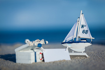 Image showing sailing boat and seashell in sand decoration closeup