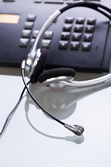 Image showing office desk with telephone and headset objects 