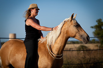 Image showing young woman training horse outside in summer