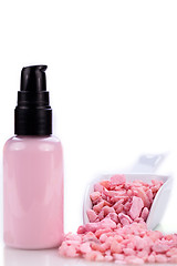 Image showing pink body lotion in dispenser and aroma salt isolated