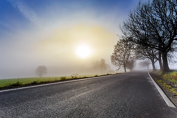 Image showing rural foggy road going to the sunrise