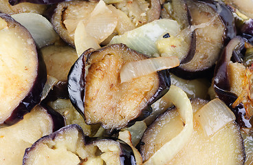 Image showing sliced and fried eggplants and onion as  background 
