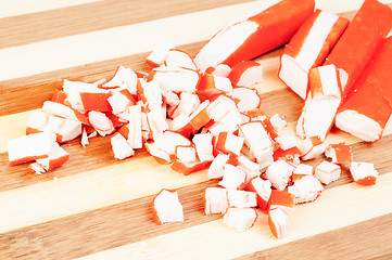 Image showing sliced crab sticks on bamboo cutting board