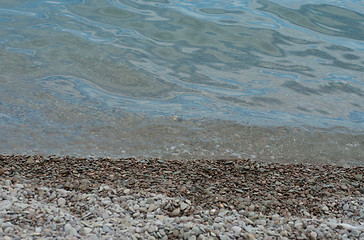 Image showing Stony shore in daylight  with sea  wave 