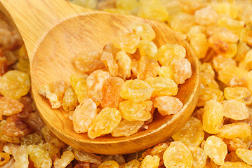 Image showing Golden raisins close- up and wooden spoon, food background