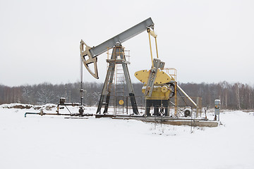 Image showing oil pump works   on winter forest  background