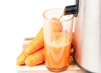 Image showing Juice machine and carrot juice isolated  on  white