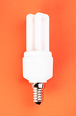 Image showing energy saving light bulb on red background 