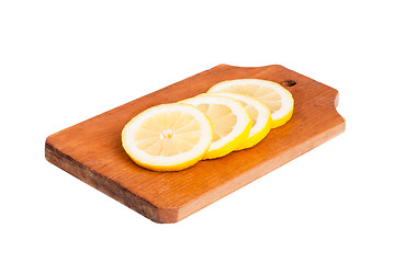 Image showing Slices of lemon  on wooden cutting board  isolated on  white