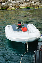 Image showing Motor boat is white with a red engine on the dock