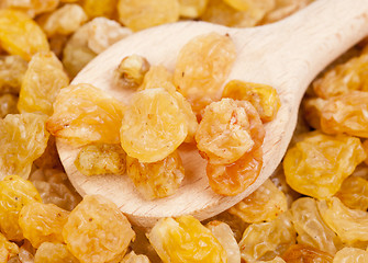 Image showing Golden raisins close- up and wooden spoon, food background