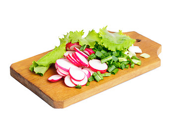 Image showing Fresh slised radish, onion and salad on cutting board isolated on white 