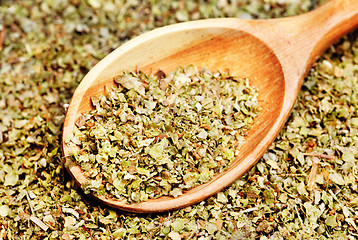 Image showing Dried marjoram spice and wood spoon as food background 