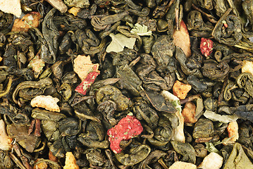 Image showing green tea with orange peel and strawberries as background