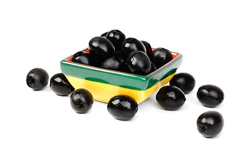 Image showing Black pitted olives in ceramic salad bowl isolated on white macro