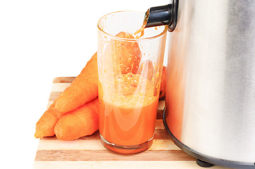 Image showing Juice machine and carrot juice isolated  on  white