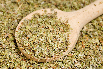 Image showing Dried marjoram spice  and wood spoon  as  food background