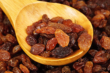 Image showing raisins and  wooden  spoon close- up food background 