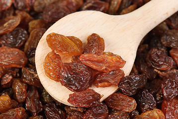 Image showing raisins and  wooden  spoon close- up food background 