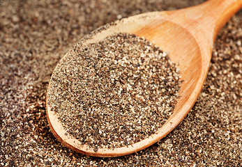 Image showing Ground black pepper (Piper nigrum) with wooden spoon 