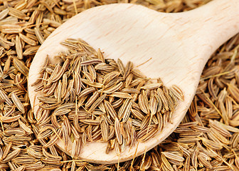 Image showing cumin seeds and wooden spoon as background 